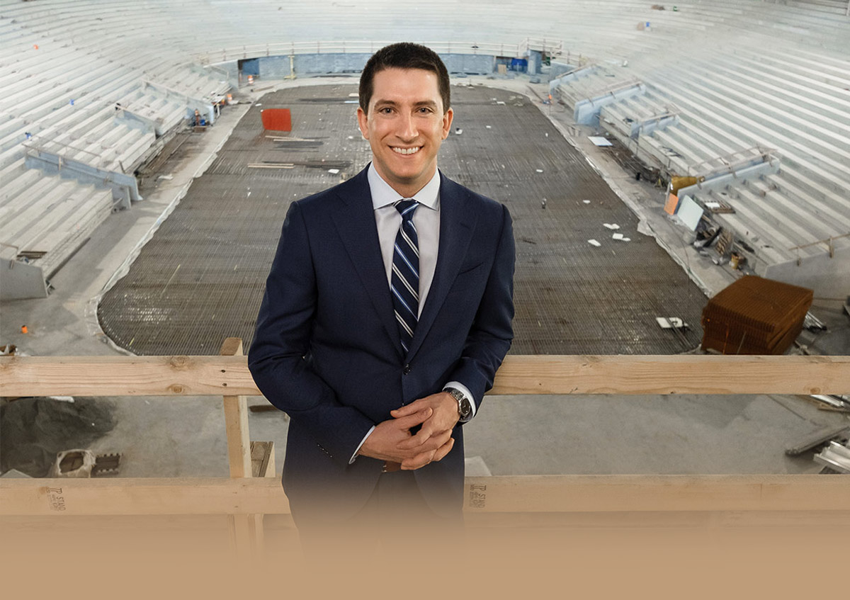 Zack Klein wearing a dark blue suit and standing in front of a construction zone