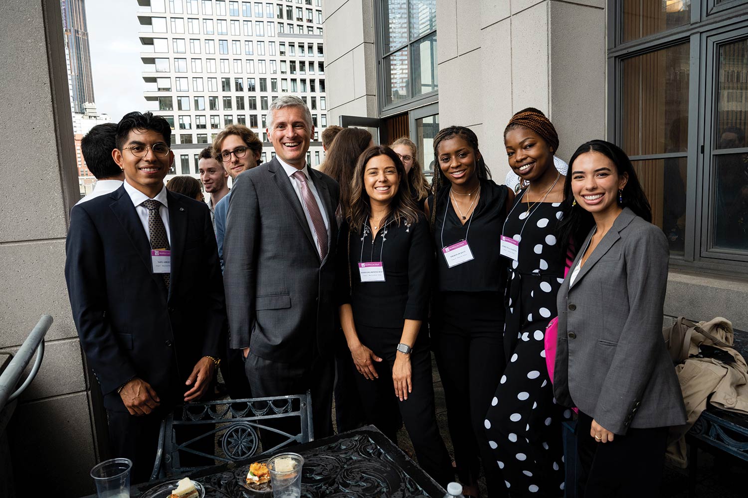 A photograph of Michael T. Cahill (President, Joseph Crea Dean, and Professor of Law at Brooklyn Law School) smiling and posing alongside students